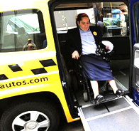 Wheelchair user exiting accessible taxi.