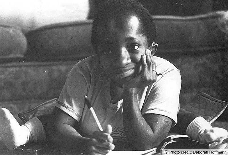 A child sits on the floor drawing and playing. Photo credit: Deborah Hoffmann