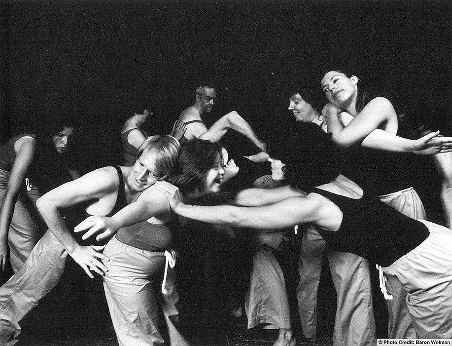 A large group of dancers entwined against a black background. Photo credit: Baron Wolman