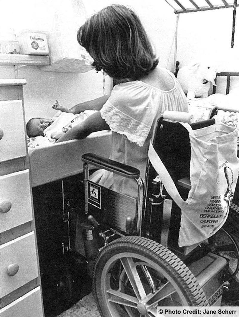 Wheelchair user changing her baby's diaper. Photo credit: Jane Sherr