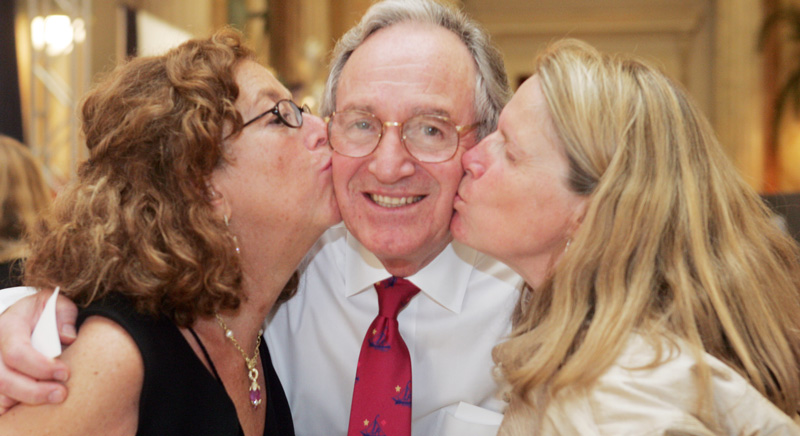 Arlene and Pat Wright on either side of Tom Harkin kissing him on the cheek