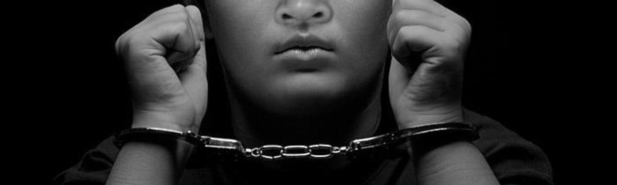 Black and white photo of child in handcuffs