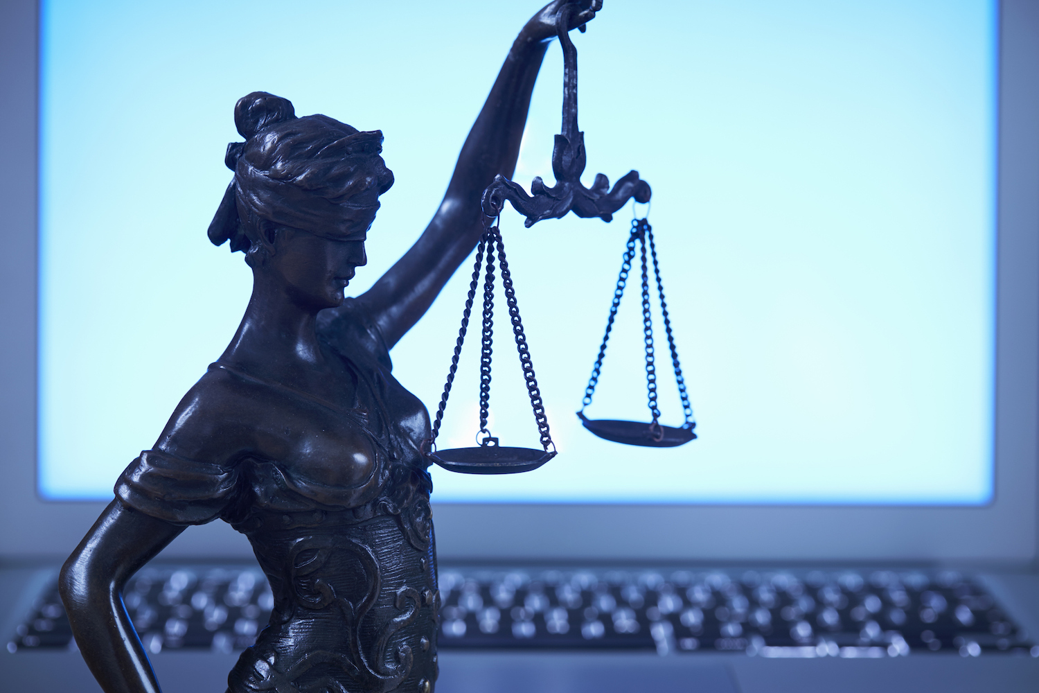 Lady Justice against laptop monitor