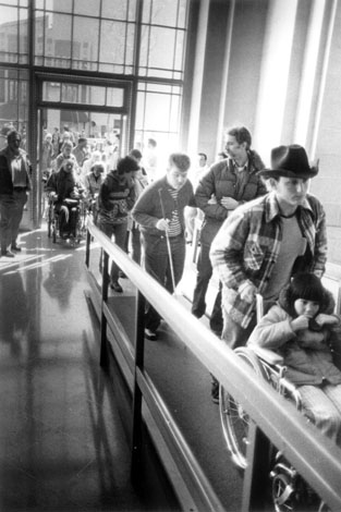 Black and white photo from 504 Sit-Ins of protesters in San Francisco, going up ramp in the HEW building