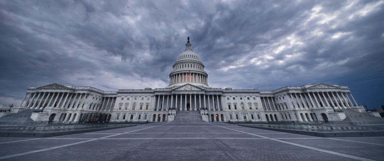 Exterior of the U.S. Capitol building with dark ominous clouds above