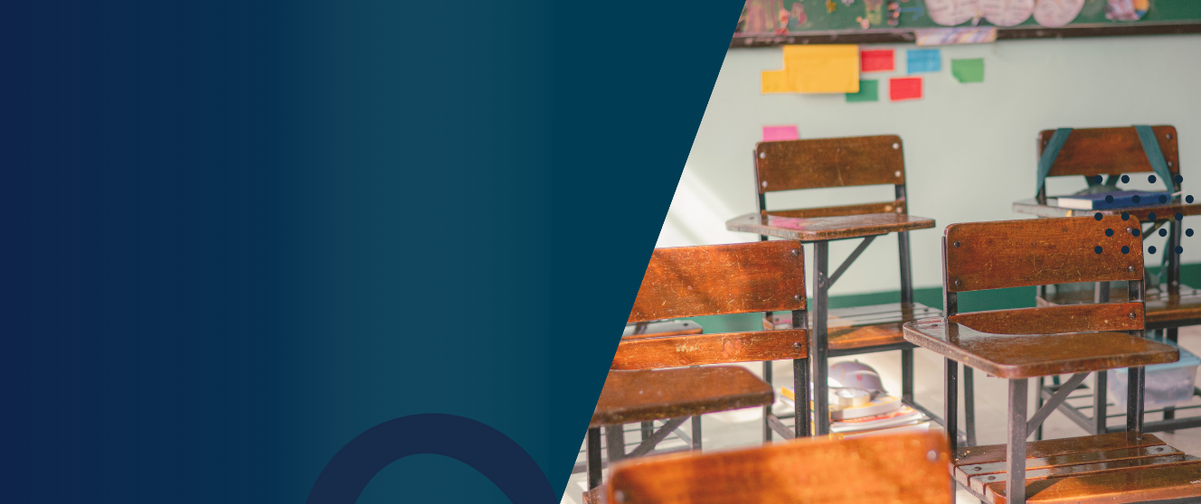 An empty classroom with wooden desks and chairs.