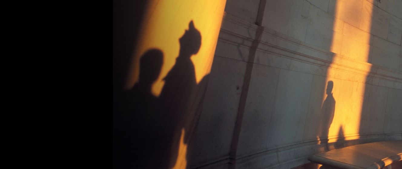 Shadows of people looking up in a monument
