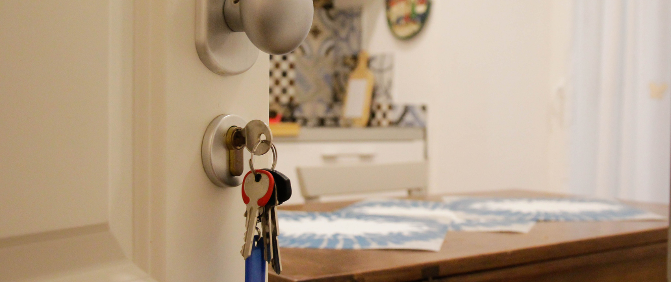 Open door to an apartment with keys left in the door