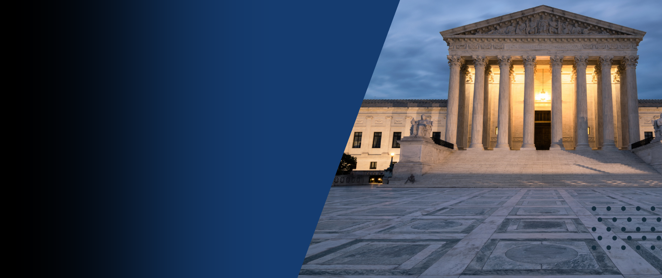 Exterior of the Supreme Court building at night.