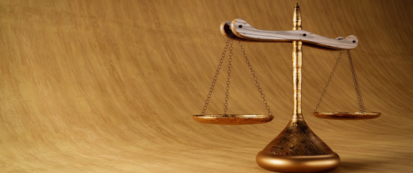 Image of gold scales of justice against a brown background.