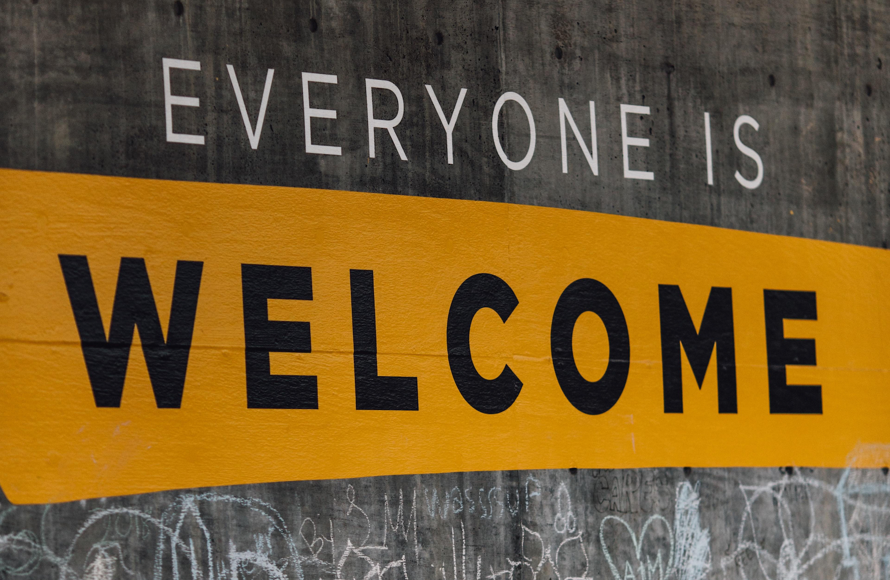 Street art on a concrete wall with words that read 'Everyone is Welcome.'